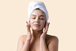© Mountains Hunter - Beauty portrait of woman in white towel on head applies cream to the face. Skincare cleansing eco organic cosmetic spa relax concept.