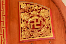 Gilded Wooden Carved Buddhist Swastika. Carved Ornament On The Door In The Buddhist Temple Brahma Vihara Arama, Bali, Indonesia. Asakusa Shrine Detail - A Golden Swastika, An Ancient Symbol Of Power