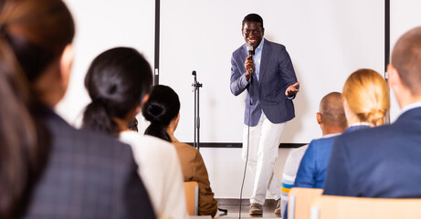 Sticker - Young emotional male motivation coach giving speech from speaker stage