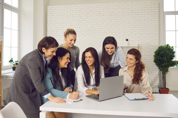 Wall Mural - Group of happy young women having fun while working on business project together