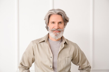 mature man with grey hair on light background