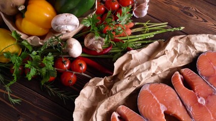 Wall Mural - Fresh raw salmon fish steak with herbs and vegetables on wooden background