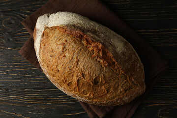 Towel with fresh baked bread on wooden table