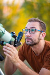 Wall Mural - amateur astronomer looking at the sky with a telescope.