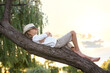 © New Africa - Cute little boy on tree outdoors. Child spending time in nature