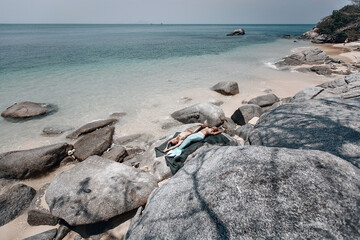 Wall Mural - two sexy fit mermaids are sunbathing on stones, on a fishnet