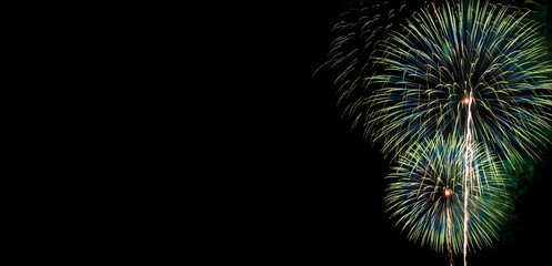 Poster - Abstract beautiful colorful fireworks display for celebration on black background with free space for text. New year holiday concept.