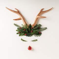 Canvas Print - Reindeer face made with Christmas bauble decoration, holly berries, antlers and pine branches. Minimal New Year December concept. Flat lay, top view.