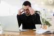 © Ivan - It doesn't work Tired male programmer massaging temples, holding head and looking for an error in the code. Remote or freelancer worker drinking coffee in cafe.