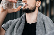 © Ivan - Man drinking water from plastic bottle after hard workout. Close up cut view of male face. Don't forget to drink during training. Take care of youself concept. Drink more water. Hydration time