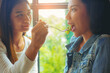 © Panumas - LGBT Lesbian Asian couple romantic moments eating vegetable salad in restaurant.