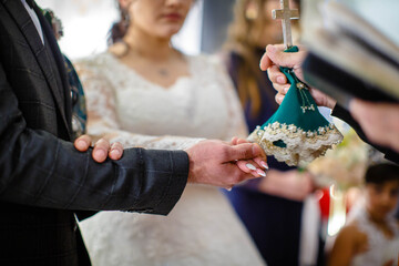 Bride and groom are holding each other's hands during church wedding ceremony