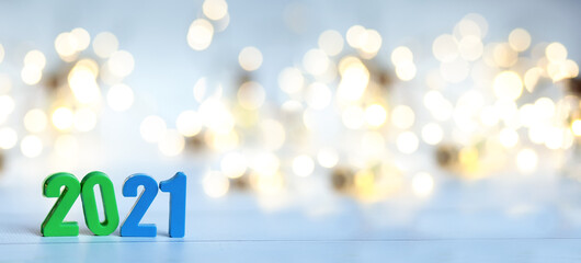 Figures 2021 on a background of garlands and bokeh. Blue, green, gold, white,  yellow background. New year banner