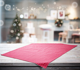 Red napkin on wooden table and Christmas background.