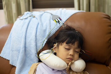 A little girl is sleeping and doing a neurofeedback exam. Making EEG electrodes.