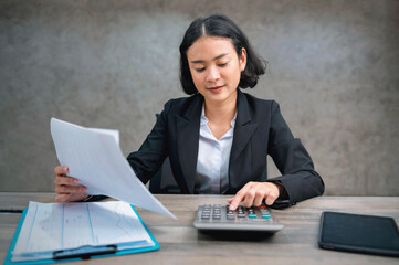 Wall Mural - woman accountant using calculator for calculate finance report in office