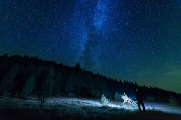 Wall Mural - fantastic starry night with galaxy milky way with a tourist and a tent on the mountain range in the 