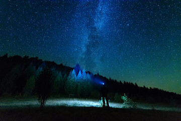Wall Mural - fantastic starry night with galaxy milky way with a tourist and a tent on the mountain range in the 