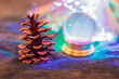 Krzyształowa kula i szyszka podświetlone świątecznymi światełkami