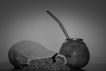 Black And White Shot Of A Calabash And A Bag Filled With Mate Isolated On A Black Background