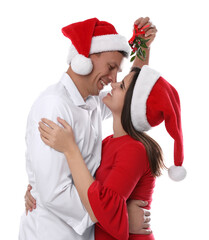 Wall Mural - Happy couple standing under mistletoe bunch on white background