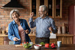© fizkes - Overjoyed emotional middle aged senior married family couple having fun preparing food together in kitchen, having playful mood. Sincere happy old husband and wife laughing, cooking meal at home.