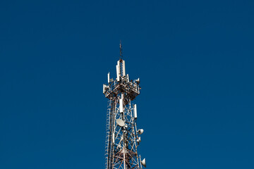 Wall Mural - Telecommunication tower with 5G cellular network antenna on vlue sky background