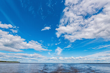 Wall Mural - panorama of calm lake, kama river blue sky with clouds reflected in the water.