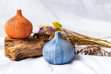 Two beautiful small ceramic vases with wooden logs on white background. Ceramic tableware, Home decor, Copy space.