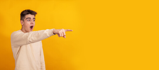 Wall Mural - teenager boy pointing isolated on background