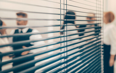 Canvas Print - through the blinds. company employees in the workplace in the office.