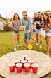 © Impact Photography - Young people having fun playing beer pong at summertime backyard party