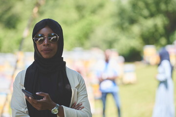 Wall Mural - african woman using smartphone wearing traditional islamic clothes