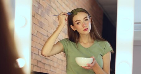 Sticker - Young woman using henna hair dye at home