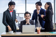 © Thinapob - Successful happy workers Group of asian business people with diverse genders (LGBT) Clap hands and congratulate to businessman see a successful business plan on the laptop computer in the meeting room