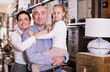 © JackF - Portrait of smiling young family in furniture store.