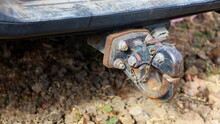 Tow Bar Behind The Truck. Trailer Hitch Is Rusty For Towing A Trailer, A Boat Or A Car On A Ground Background With A Copy Area. Selective Focus