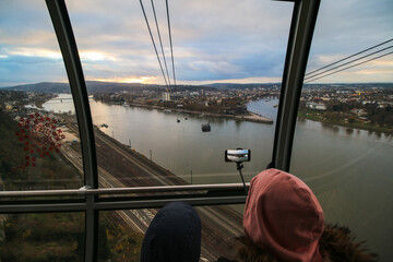 Two children looking at the amazing view of the Rhine with the selfie stick on the cable railway car