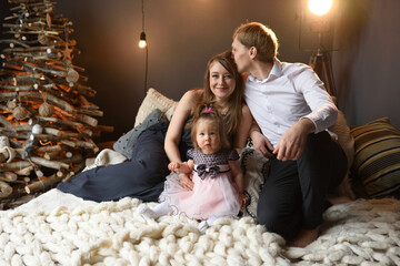 Wall Mural - Father mom and their little one year old daughter have fun together before christmas.