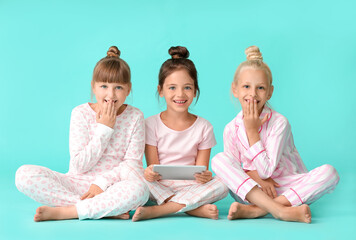 cute little girls with tablet computer on color background