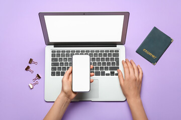 Hands with laptop, mobile phone and passport at workplace