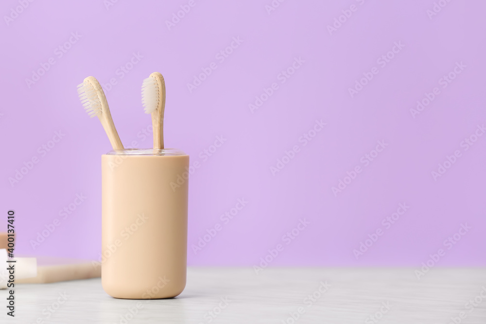 Holder with wooden toothbrushes on table