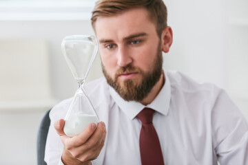 Canvas Print - Businessman with hourglass in office