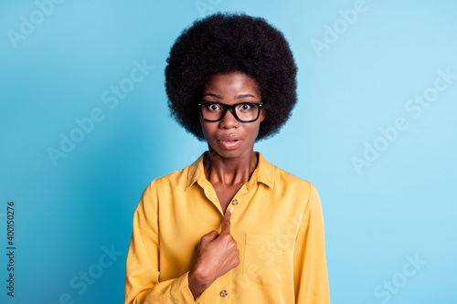 Photo of dark skin big volume hairstyle woman unsure direct herself successfully passed actress casting unbelievable speechless wear eyeglasses yellow shirt isolated blue color background
