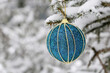 Christmas toy ball hanging on a snow covered fir branches. New Year tree with decoration