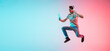 © master1305 - Music, drive. Young caucasian man's jumping on gradient blue-pink studio background in neon light. Concept of youth, human emotions, facial expression, sales, ad. Half length, copyspace. Flyer