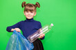 © Svetlana - Little cute girl sorting plastic bottles into trash bag isolated on green background
