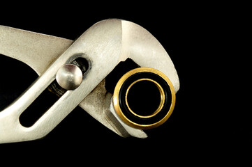 Wall Mural - Plumber wrench with brass fitting on black background. Plumbing repair idea