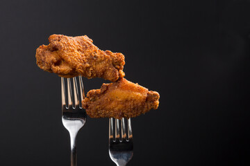 Breaded Fried chicken wings drum and flat on a fork with copy area