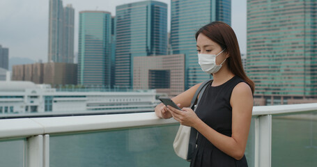 Canvas Print - Woman wear face mask and use of smart phone in city